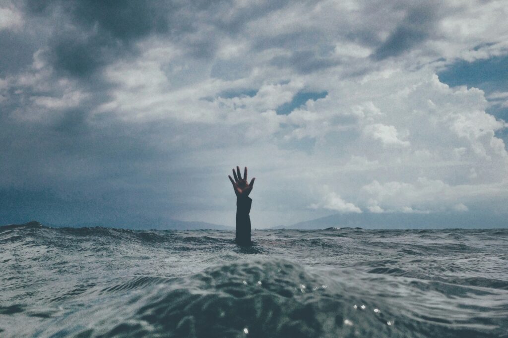 Picture of the sea with a hand held up out of the waves